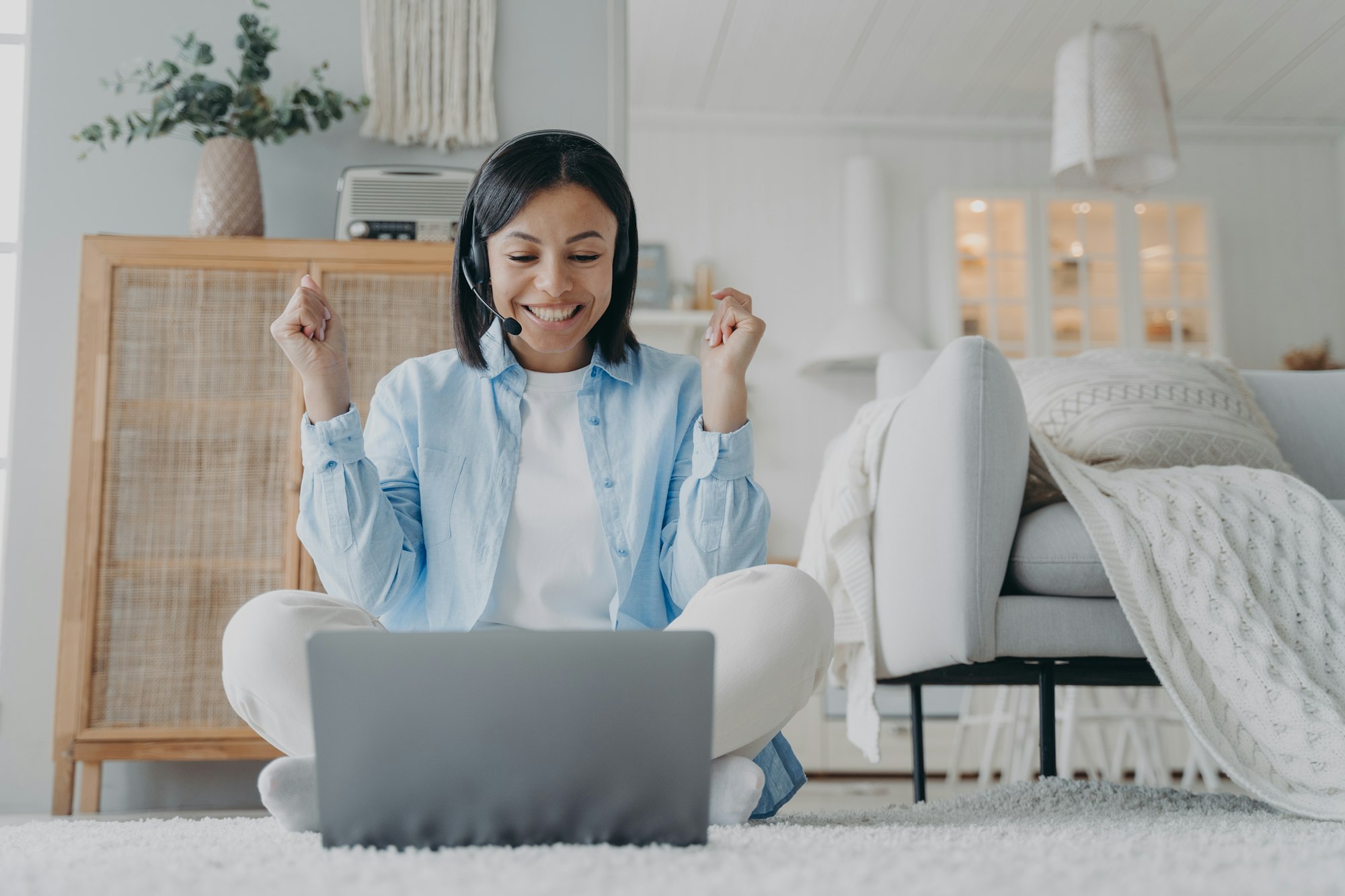 Friendly woman coach in headset working online on laptop conducts webinar at home. Elearning